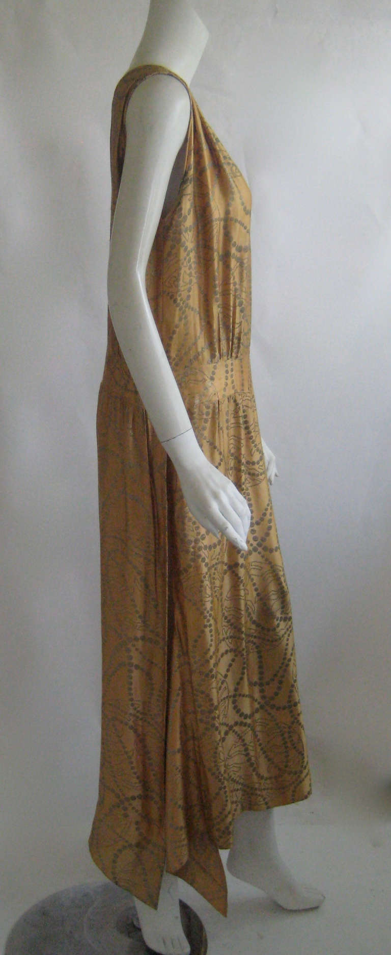 Stunning silk lame flapper dress. 
This snaps up the side and and is has an attached sash at one hip .The material is a heavy metallic silk lame that is very strong and wearable.This originally had a lining which was removed but the silk is not at