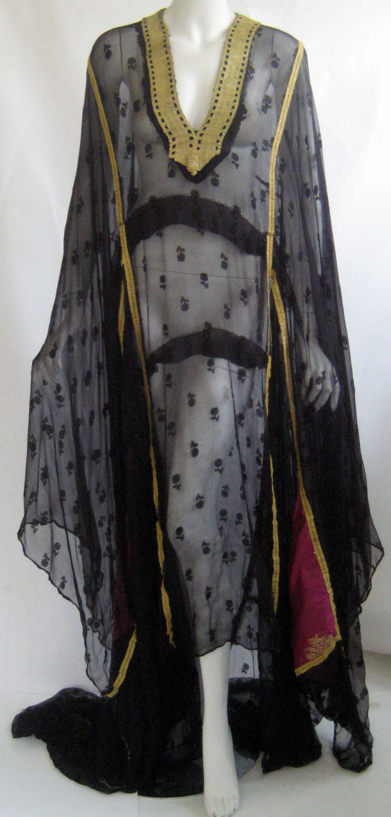 Wonderful silk chiffon caftan with fuchsia silk triangular inserts and gold  bullion trim 
Most likely Persian Gulf in origin
This is cut in a t shape with very wide sleeve cuffs 
Train in back 
Wearable with care
Shown on a size 6 mannequin