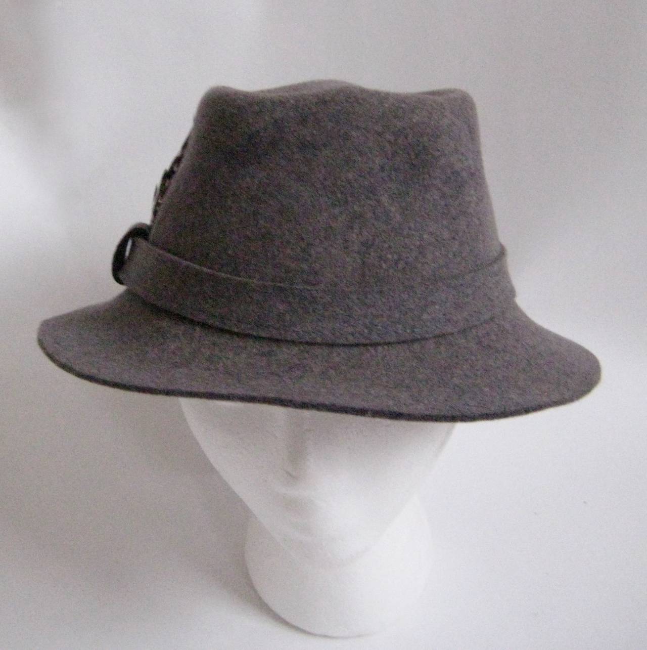 Lovely Halston wool felt fedora with a matching band and a tiny feather.
This hat measures approx around when measured from the inside