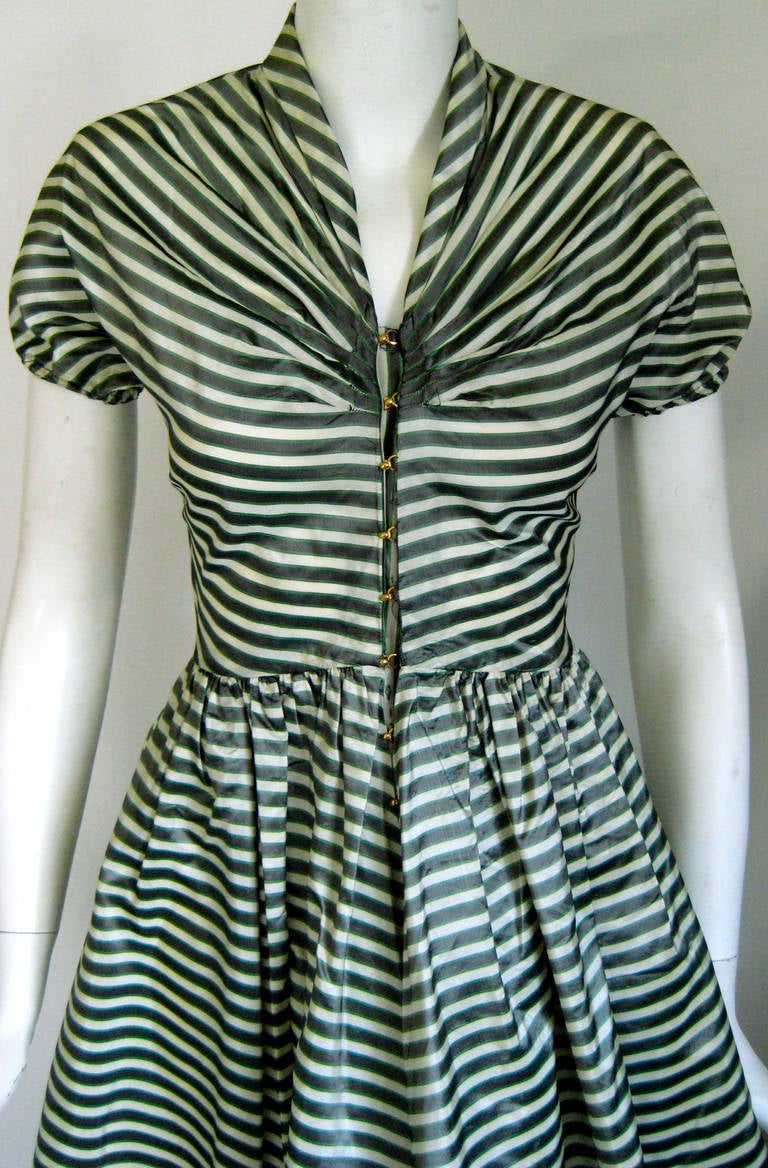 Wonderful party dress
 Signature Mccardell gold tone fasteners down the front
Slightly puffed cap sleeves

Cream ground with stripes that are somwhere between a deep greenish grey and hunter green bordered with thinner stripes of a brighter, not