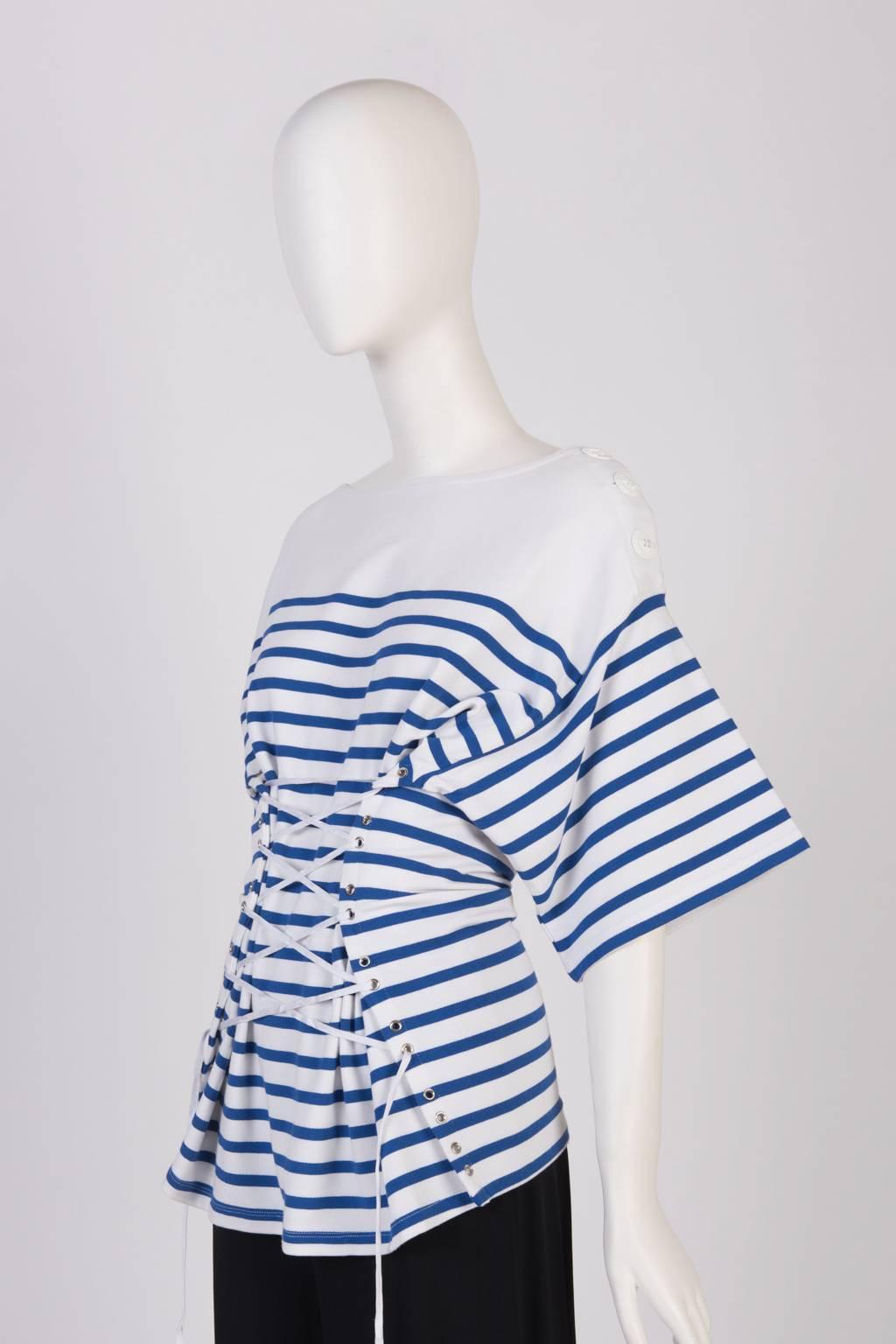 Noat neck top with 3/4 sleeve and front laced cinched waist in the French designer's classic Breton stripe. Side neck closure trimmed in grosgrain and a trio of  white anchor buttons. Tie-up detail.