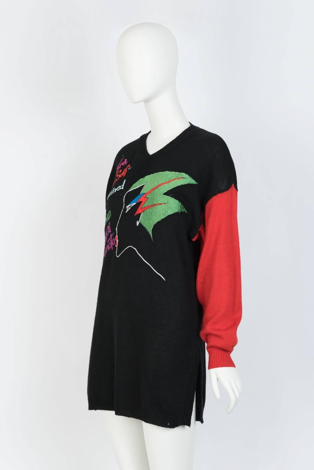 Embroidered, V-neck, wool blend sweater with cuff sleeve and side slit hem from the designer's late 80's series of statement knits. Text reads: 