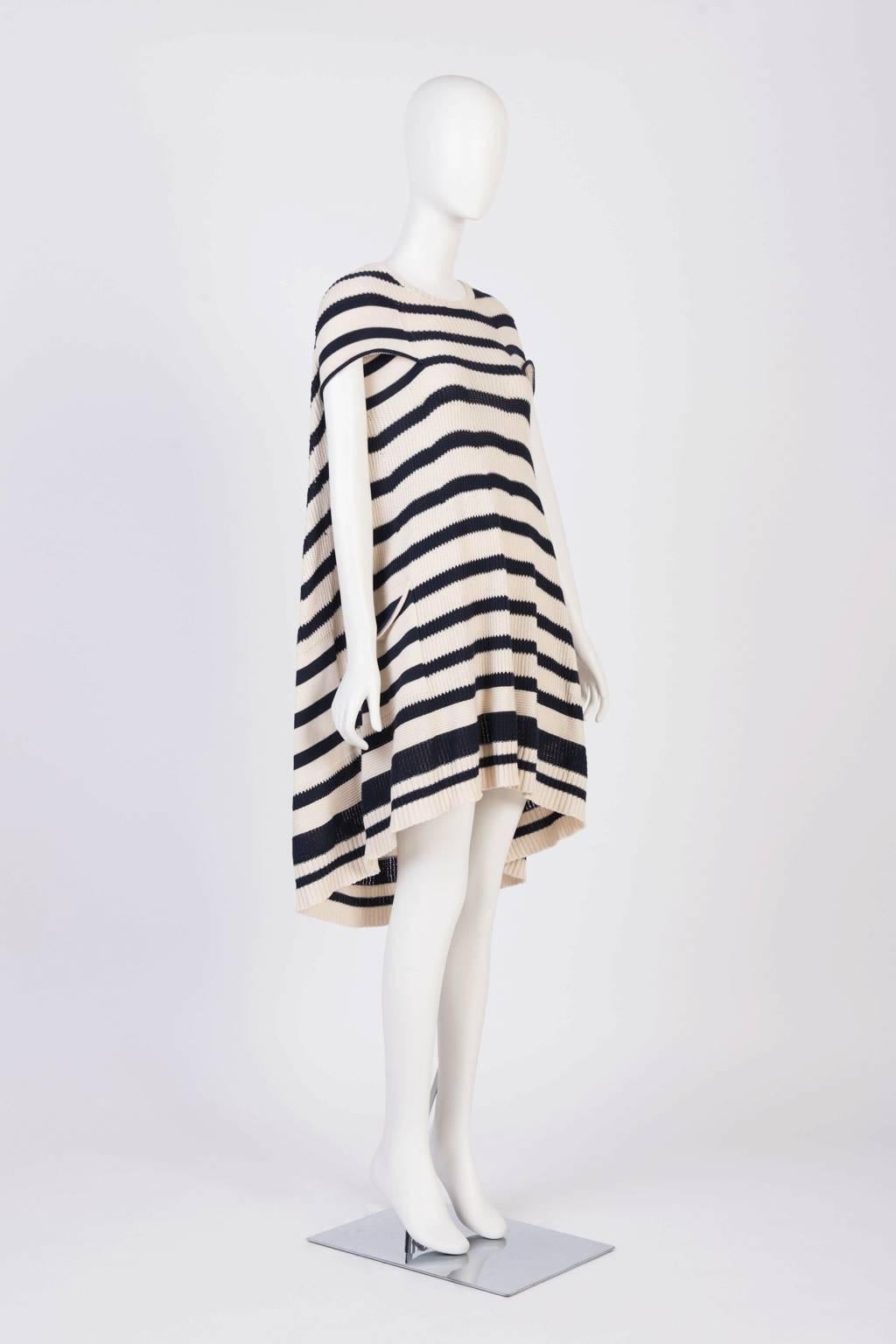 Blue and cream, knit poncho dress with knee length asymmetrical hem, capped sleevss, and patch pockets.