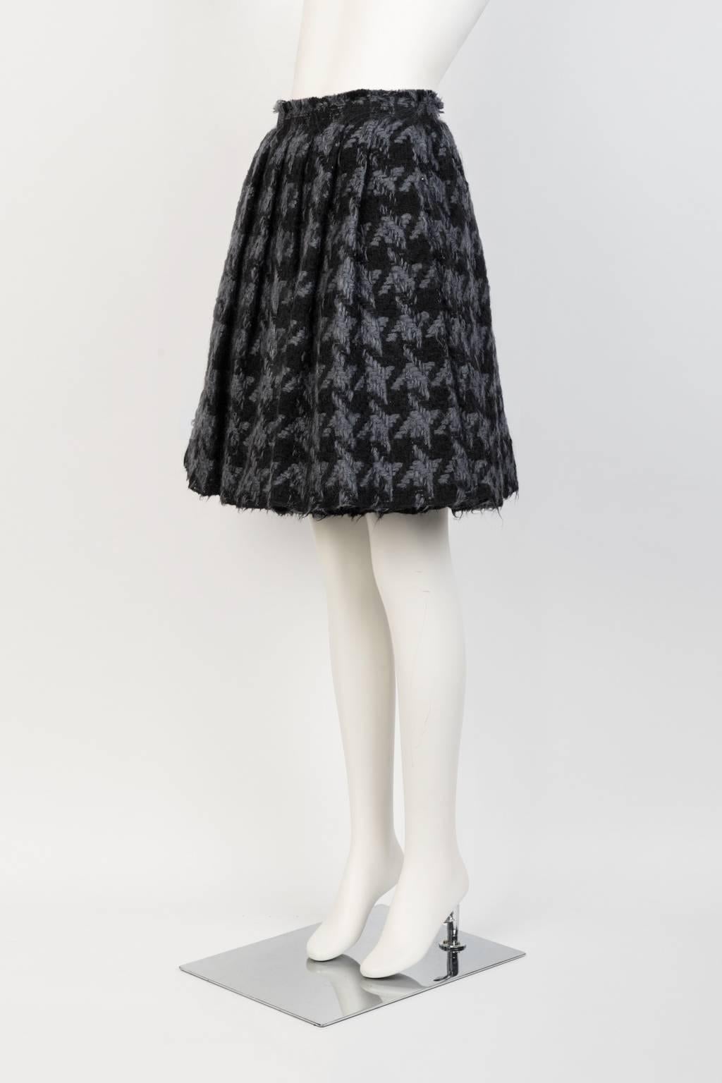Swingy, hand pleated, over the knee skirt in grey and black houndstooth check with raw edge hem and waistband.