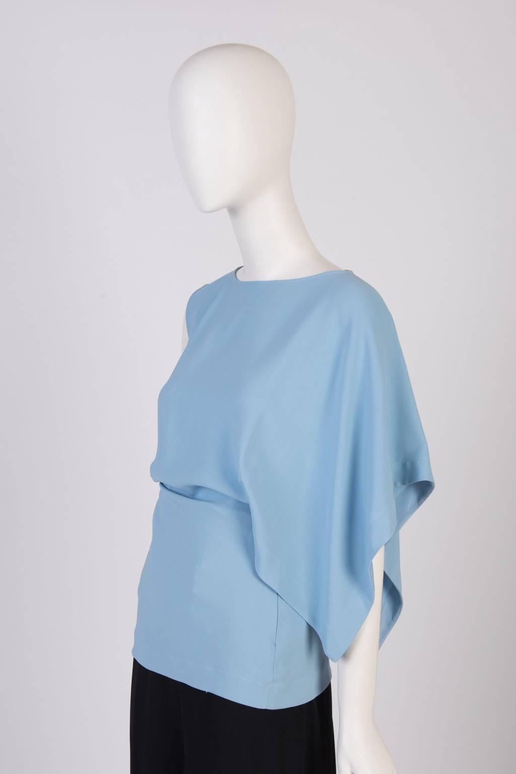 A modern and fluid Vionnet bias cut top featuring one open sleeve design with side zip fasterning. 