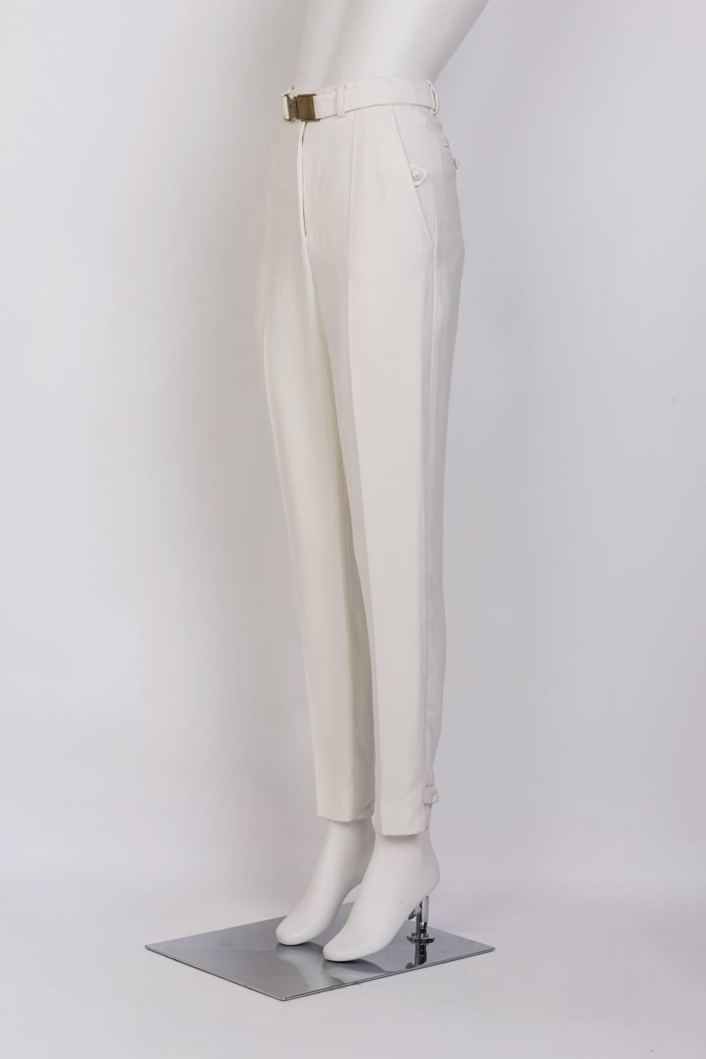 Slim white crepe trouser with gold buckle; button detailing at pocket and cuff.