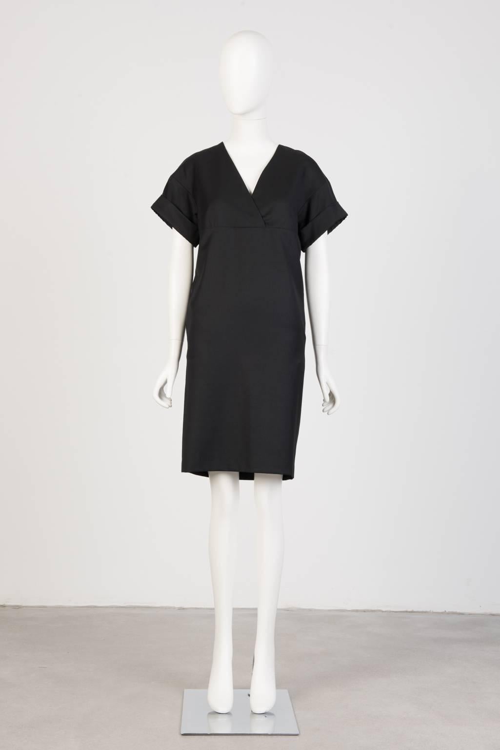Black, knee-length dress with empire waist and cuffed kimono sleeve in medium weight wool twill.