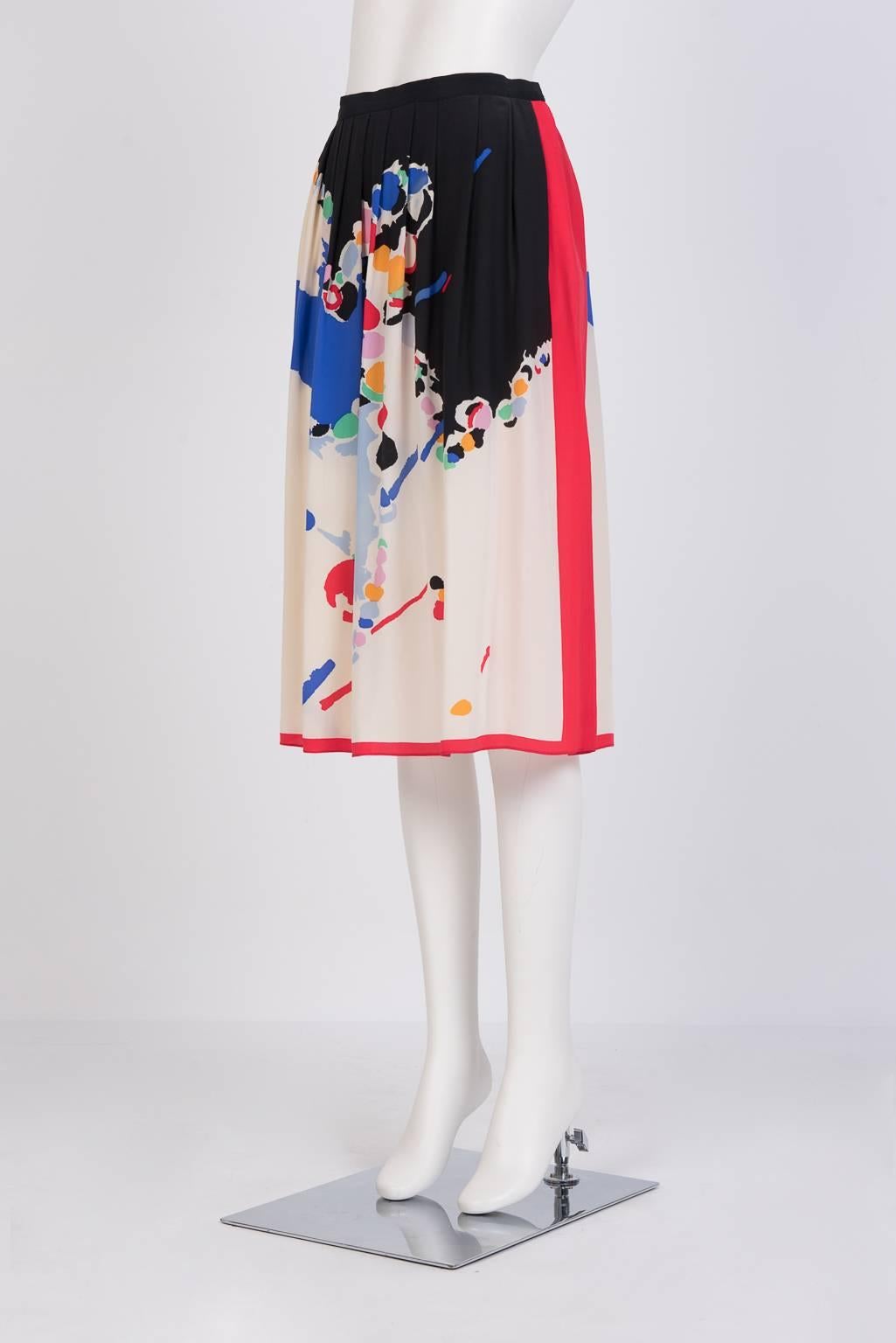 Knee-length knife-pleated skirt in a multi-coloured modernist-motif print with bold red edges.
Carre-style scarf  in multi-coloured modernist-motif print with bold red edges. 
