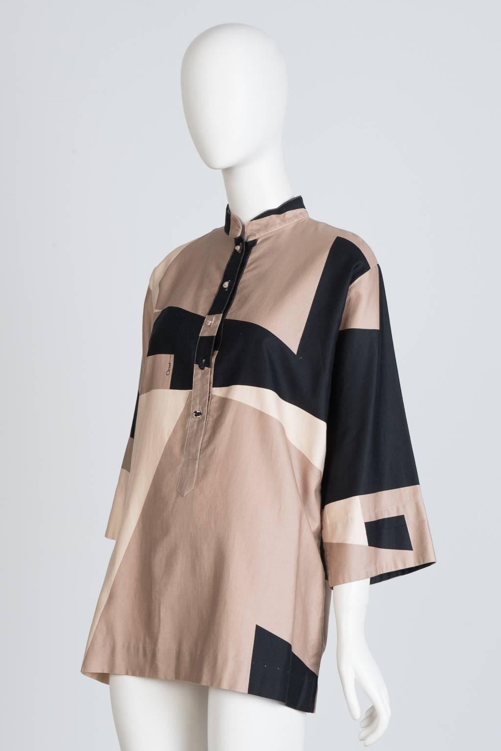 Five button, band collar tunic blouse with 3/4 length sleeves and graphic print; rose  gold, cream, and black.