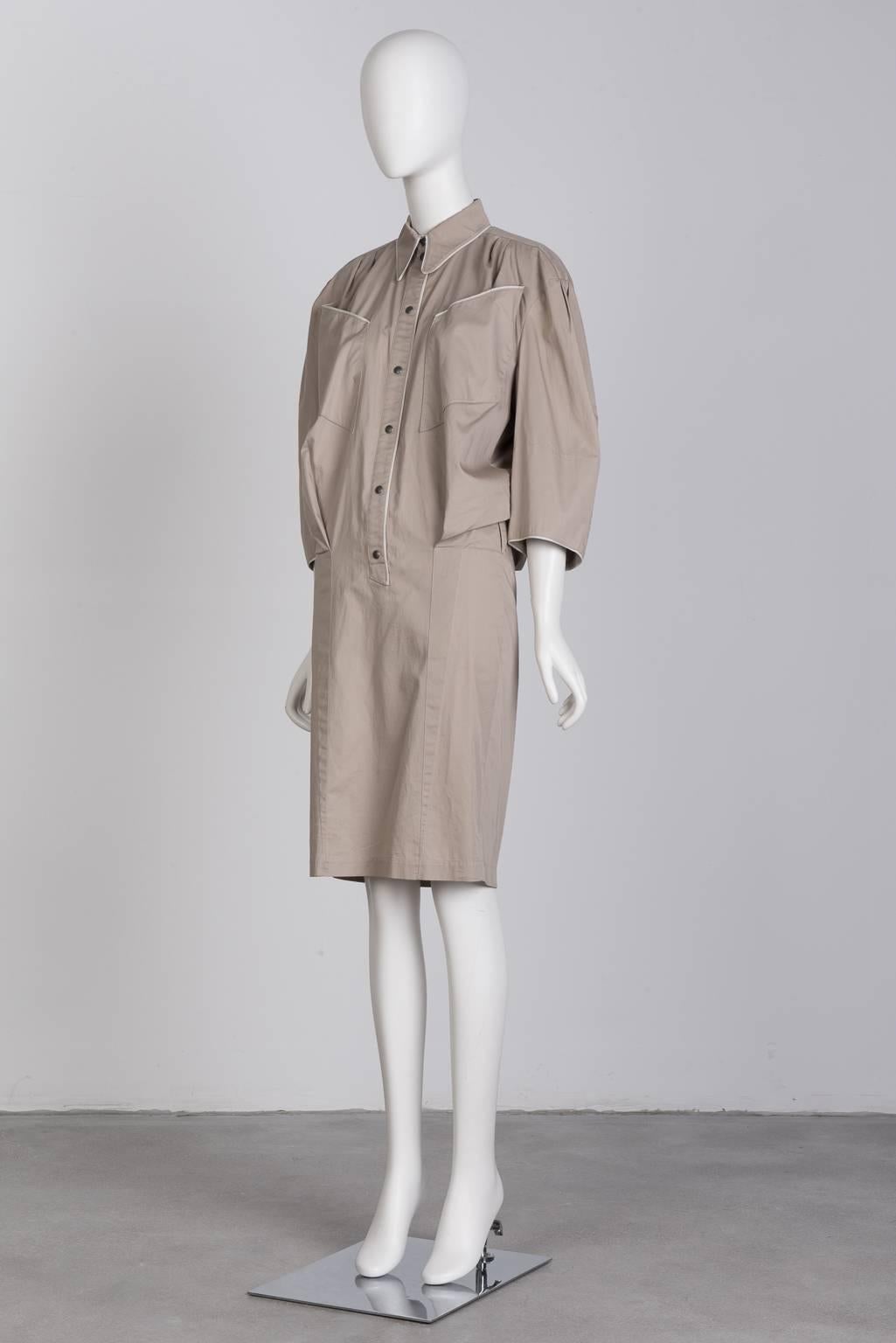 Khaki, cuffless, knee length dress with white piping and snap closures.