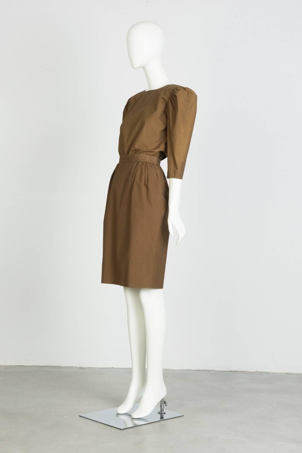 Elbow length, button back blouse in tan cotto nwith puffed, pleat shoulder.
Band waist, pleated skirt in tan cotton.