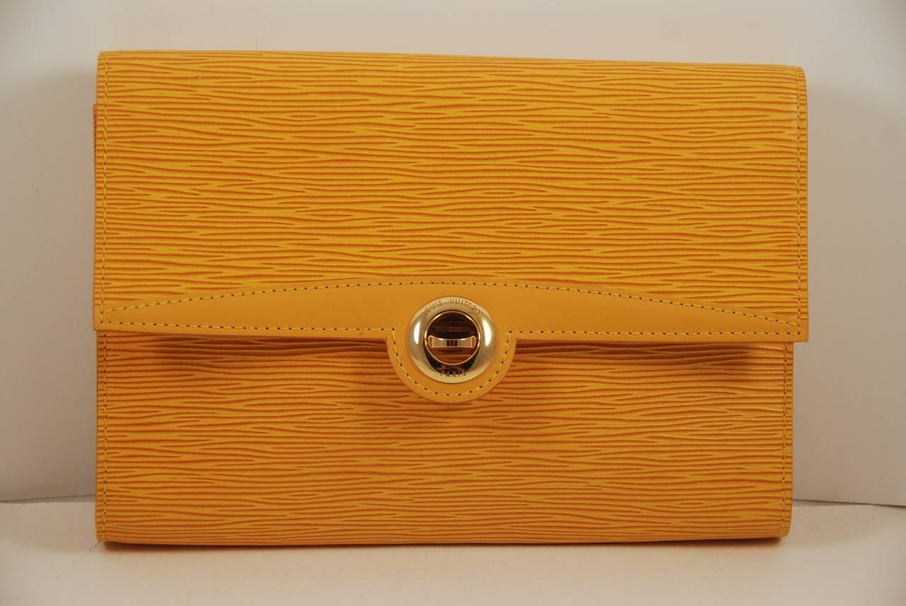 Louis Vuitton Epi Leather clutch/shoulder bag in a mustard yellow. Inside is lined in a deep purple. Date stamp is on the inside right front part of the bag and was impossible for me to photograph but the number is A2089 and I think the last digit