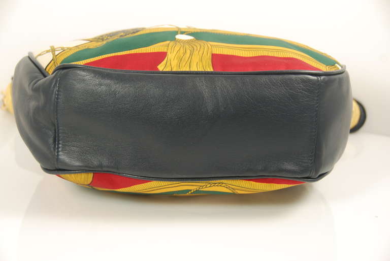 This bag reminds me of St. Tropez. It is a great bag by a fine Italian handbag firm. The front and back of the bag are in heavy silk that has a pattern and coloration in the style of Hermes. The leather handle and sides and bottom of the bag are