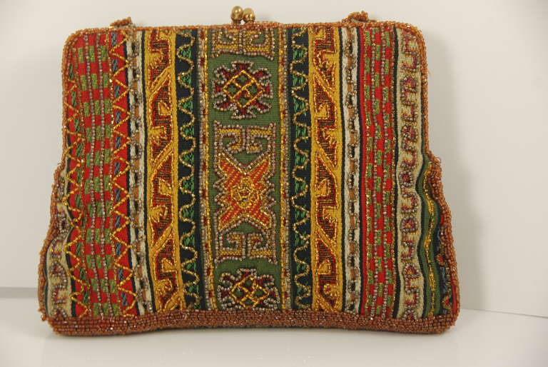 Fantastic Josef beaded bag made in Belgium in earth tones and lined in brown satin. The beads are applied over a fabric that looks similar to some oriental rugs. It is just so different and exciting looking. The beaded handle has a a 4.5