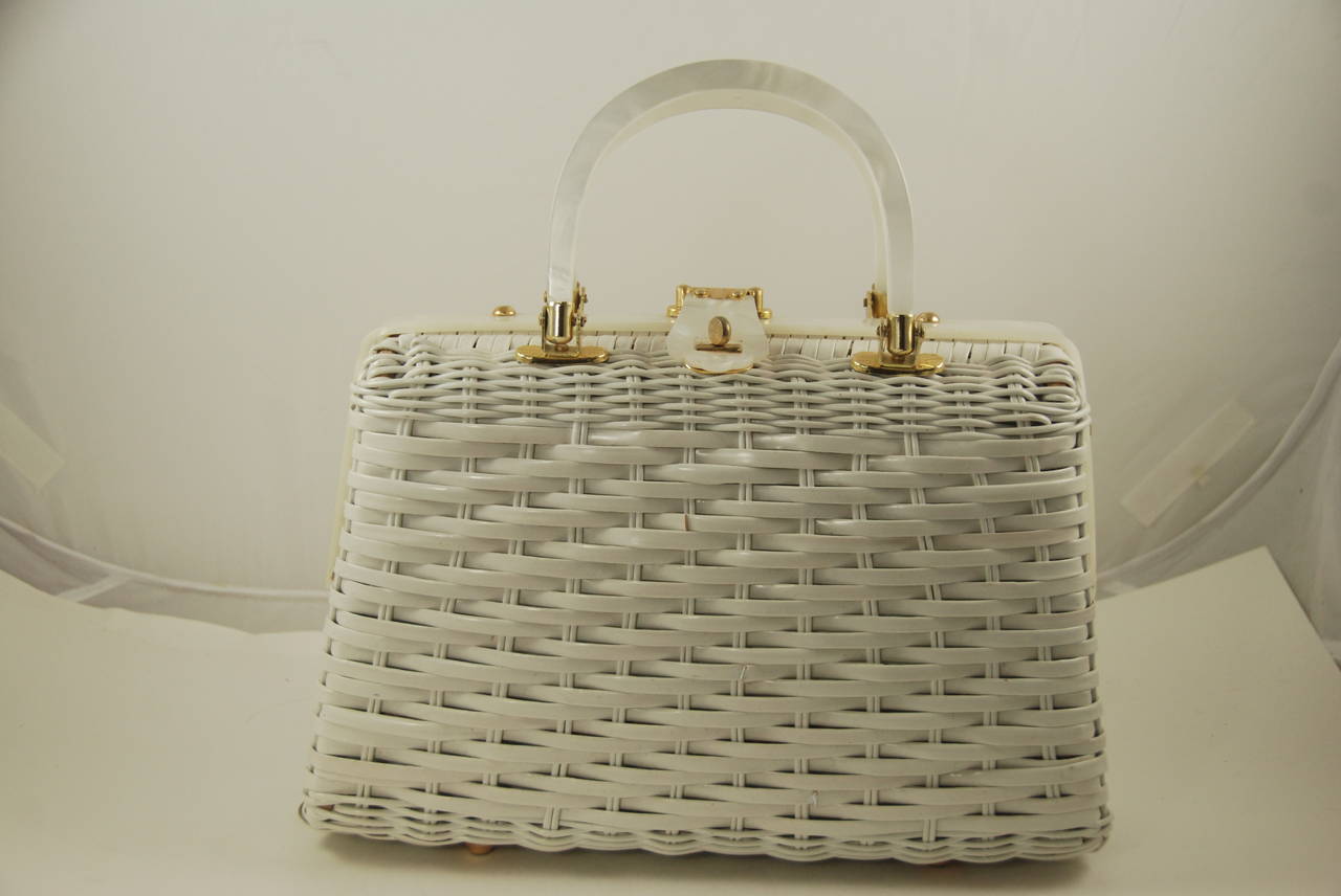 This bag is all about having fun with fashion. White woven wicker bag with sea shell decoration on the front. The shells form the shape of a crab with snail shells for the eyes. Inside is lined in white vinyl and there are two compartments and a