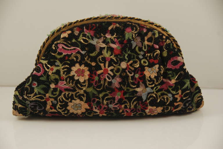 Excellent example of a vintage beaded and embroidered evening bag made in France in the 1930s. This bag combines beading and beauvais  embroidery and beading. The beads on the body of the bag provide the background for the colorful stitchery. The