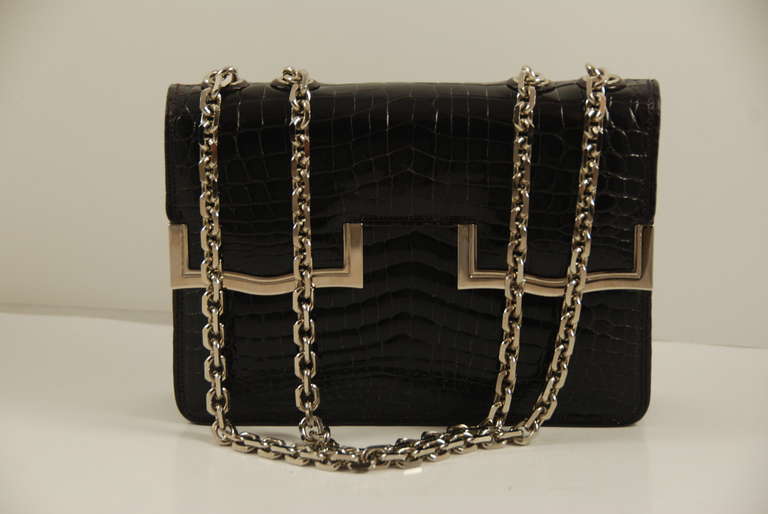 Leiber dark born alligator bag with silver chain. When the chain is doubled the bag is a handbag, when one end is pulled through the bag can be used as a shoulder bag. The metal detail on the bag is silver tone. Inside is lined in brown and bronze