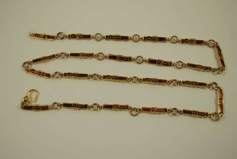 Fine enamel link belt is a coppery brown color and gold tone metal. Each link looks like a belt buckle and is 1.33 inches long. Each link is signed on the back. This wonderful belt could function as a necklace as well.