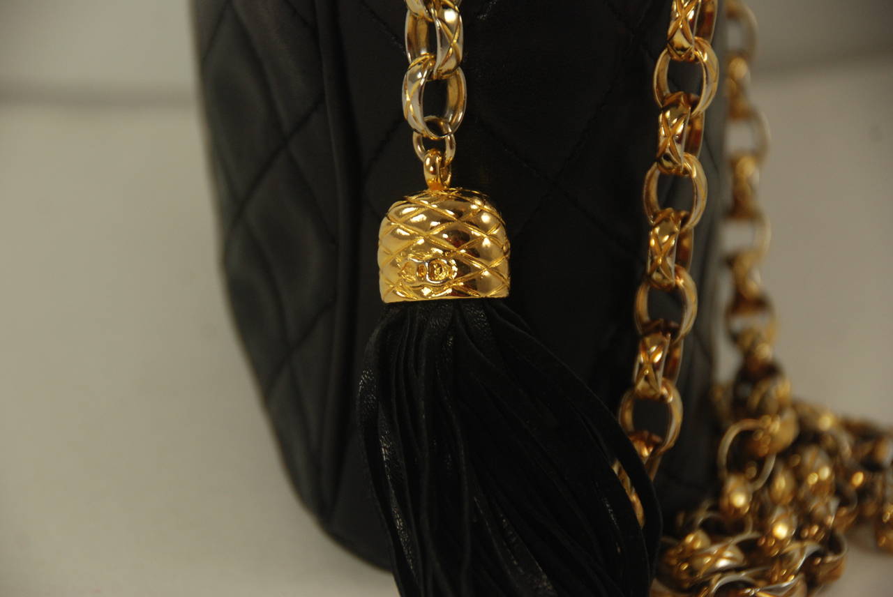 Vintage black Chanel shoulder bag circa 1980s. Bag has a stitched quilted pattern. The leather is soft lambskin. Gold shoulder chain has a  19