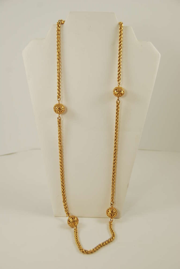 Chanel gold chain necklace interspersed with gold filigree balls. This piece is from the Autumn 1995 collection. Decorative fish hook clasp with the Chanel interlocking C's. Balls are approx 5/8