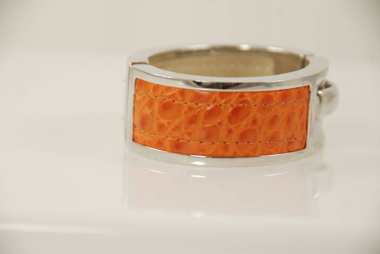 Sterling silver and burnt orange alligator bracelet by Paul Morelli. The buckle clasp is worn to the side. The silver on this bracelet is quite substantial. Paul Morelli jewelry is carried in better stores such as Neiman Marcus and high end jewelry