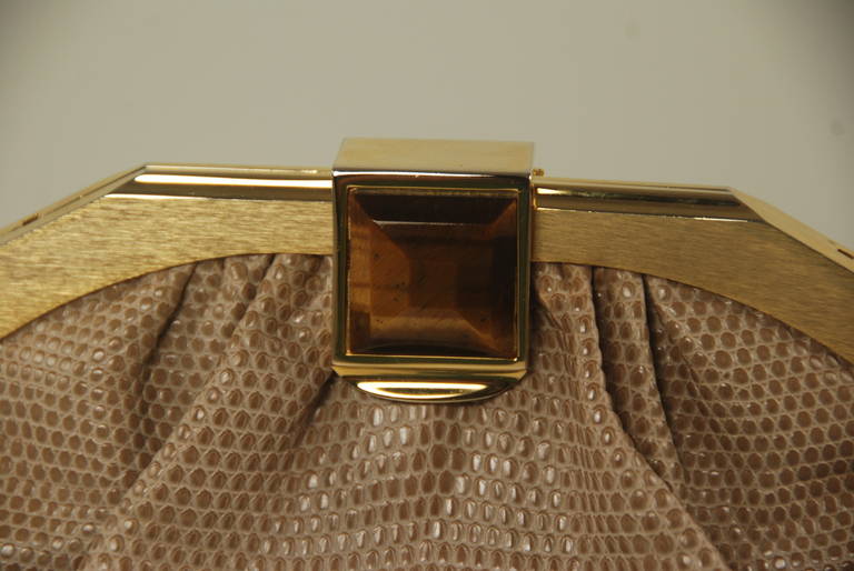 Judith Leiber karung (lizard) bag from the 1980s. The clasp is one large tiger eye stone, the clasp works well and the bag closes securely. The optional strap has a maximum length of a 19