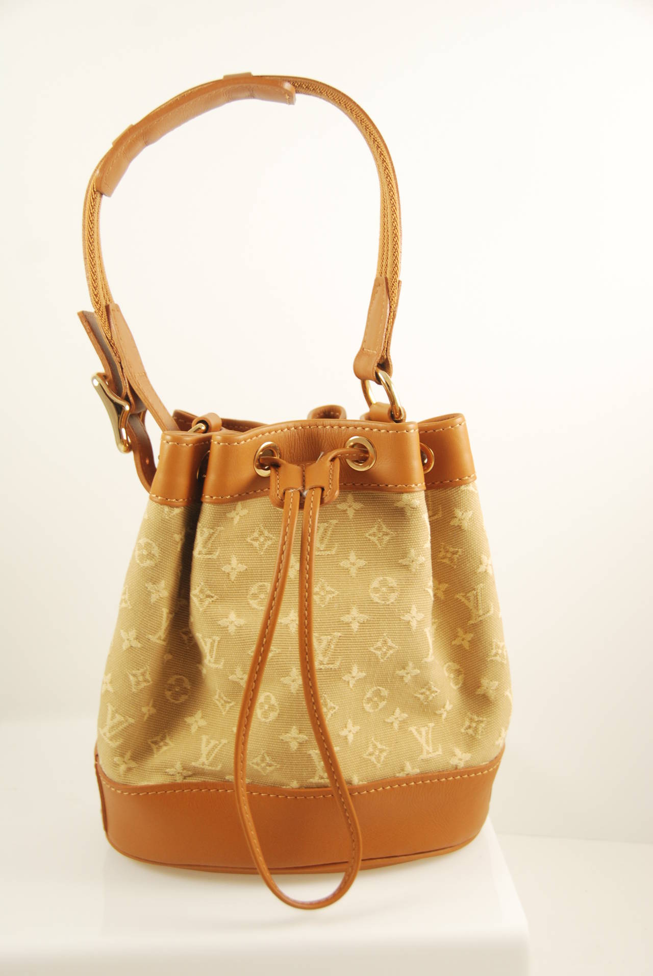Louis Vuitton mini Noe bucket bag in tan calf skin trimming, strap and base. The body of the bag is is monogram Idylle canvas. Hardware is shiny brass and has a thread leather closure. The strap has a 6.5