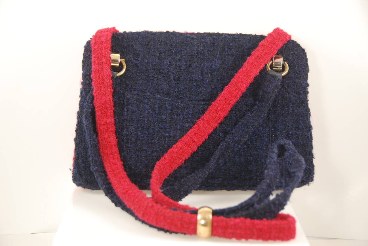 Fantastic vintage Chanel bag from the late 1960s early 1970s. One side of the bag is red and the other side is navy blue. Made of a tweedy fabric. There are two open sections and a center closed section.  Inside there are two slip compartments and