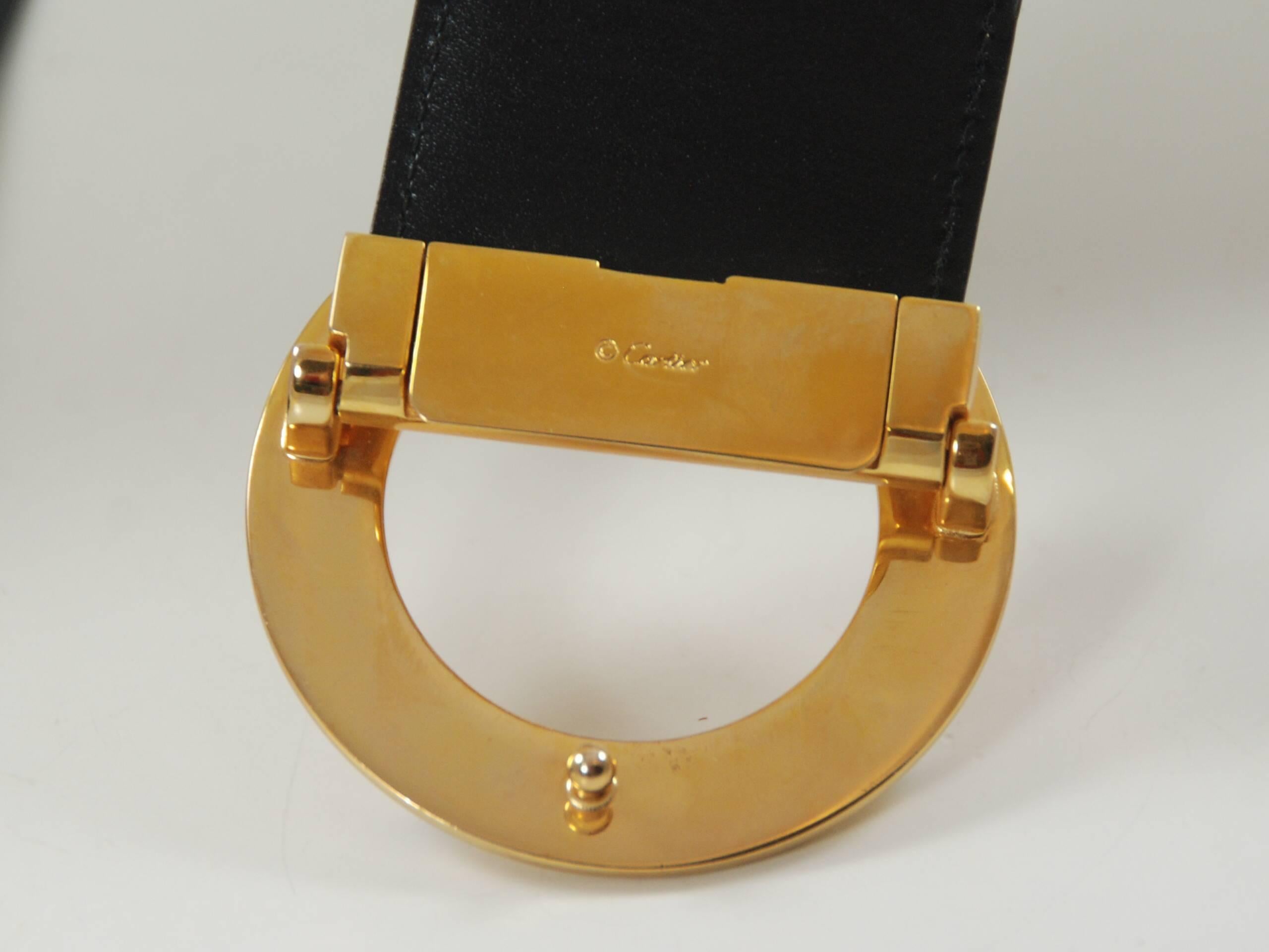 Beautiful black belt by Cartier Paris. Giraffe style buckle. Buckle measures 2 1/2 inches and is signed Cartier. The belt measures a total of 32 1/2