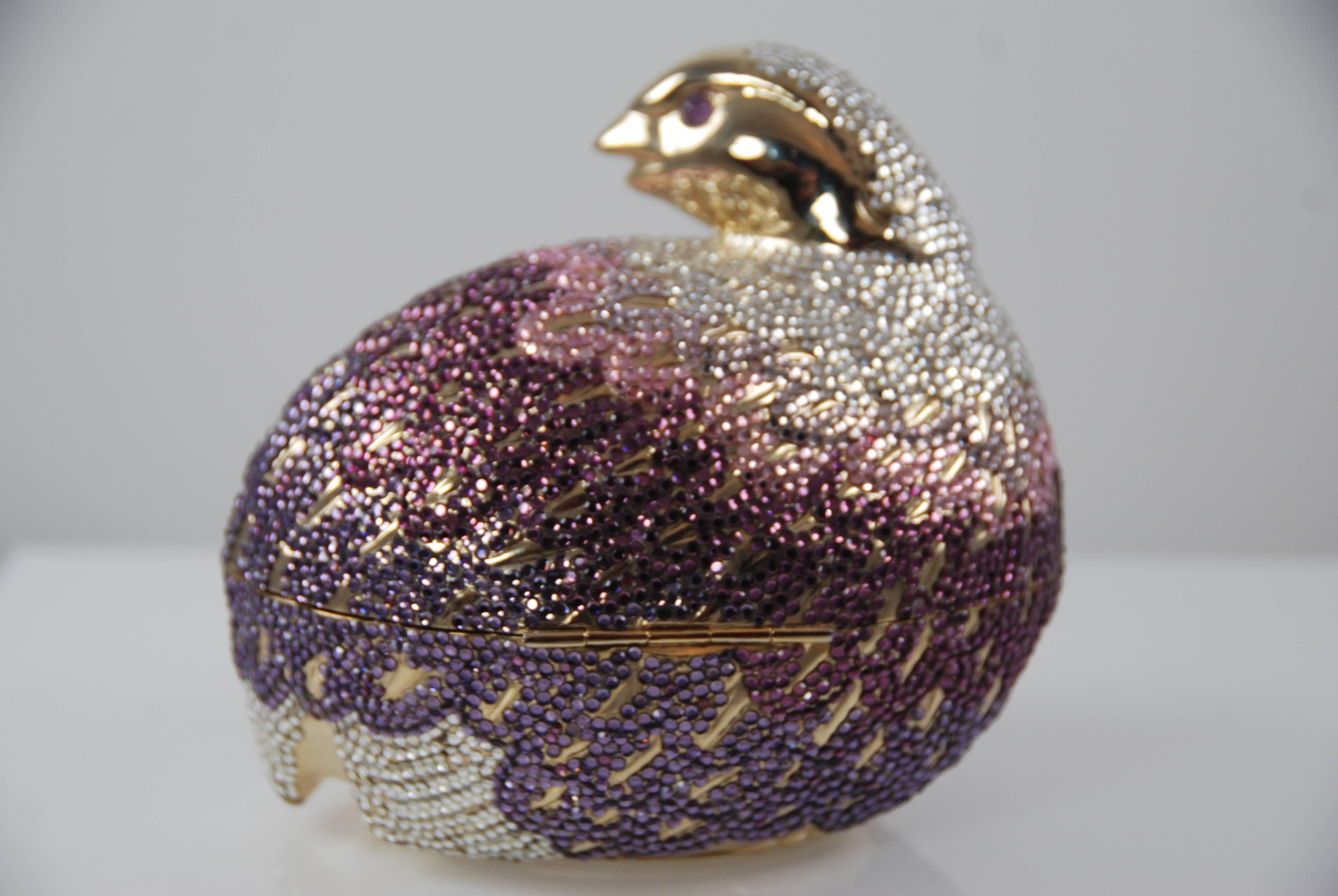 Judith Leiber fantastic bird in shades of purple, pink, and clear with amethyst eyes.  In goldtone metal, leather bottom, optional shoulder strap. Leather lining.