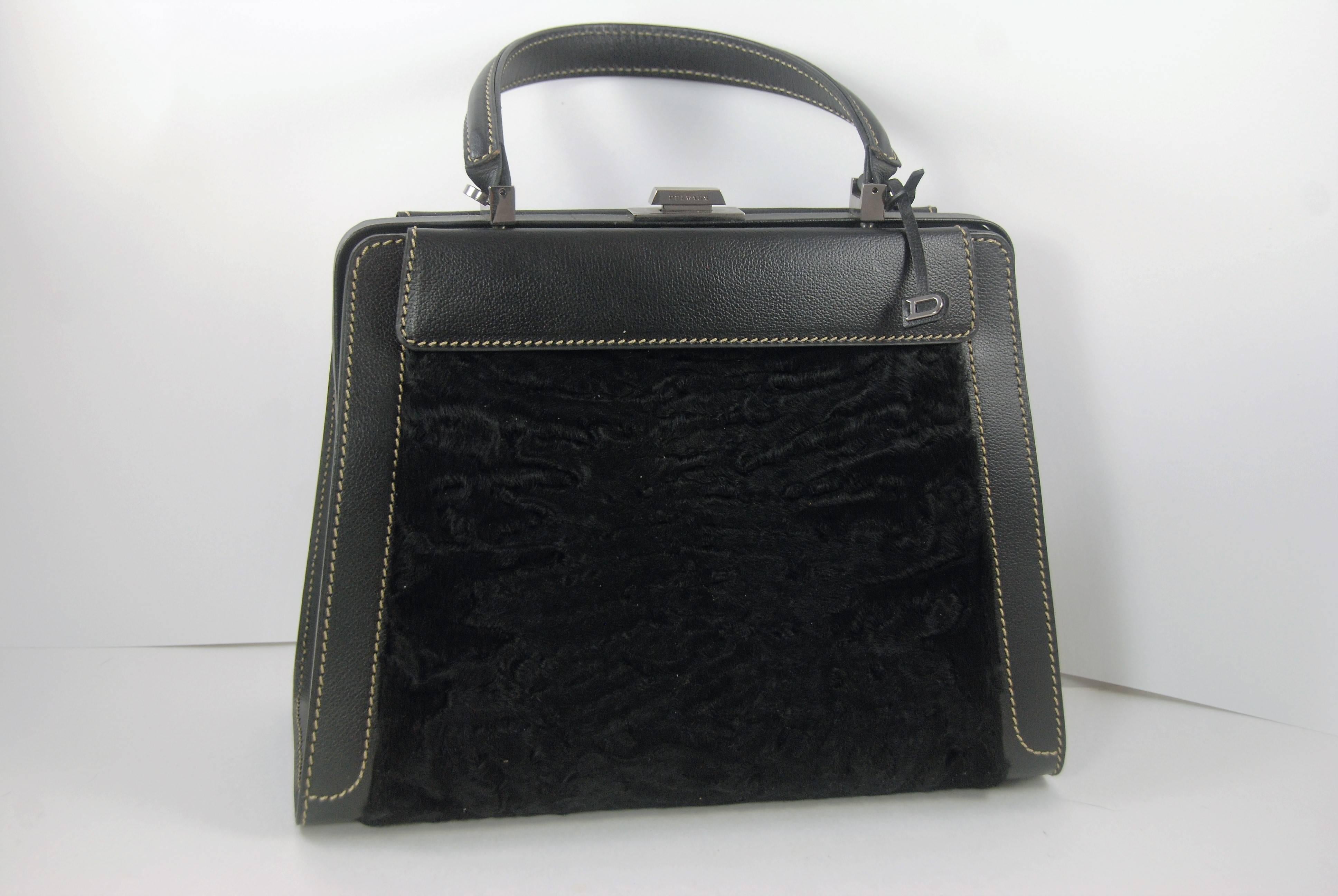 Delvaux black leather Illusion bag with removable broadtail cover and gunmetal hardware.The broadtail cover is removable and attaches by snaps that are located under the front and rear flaps. With the broadtail off, this is a great day bag, with it