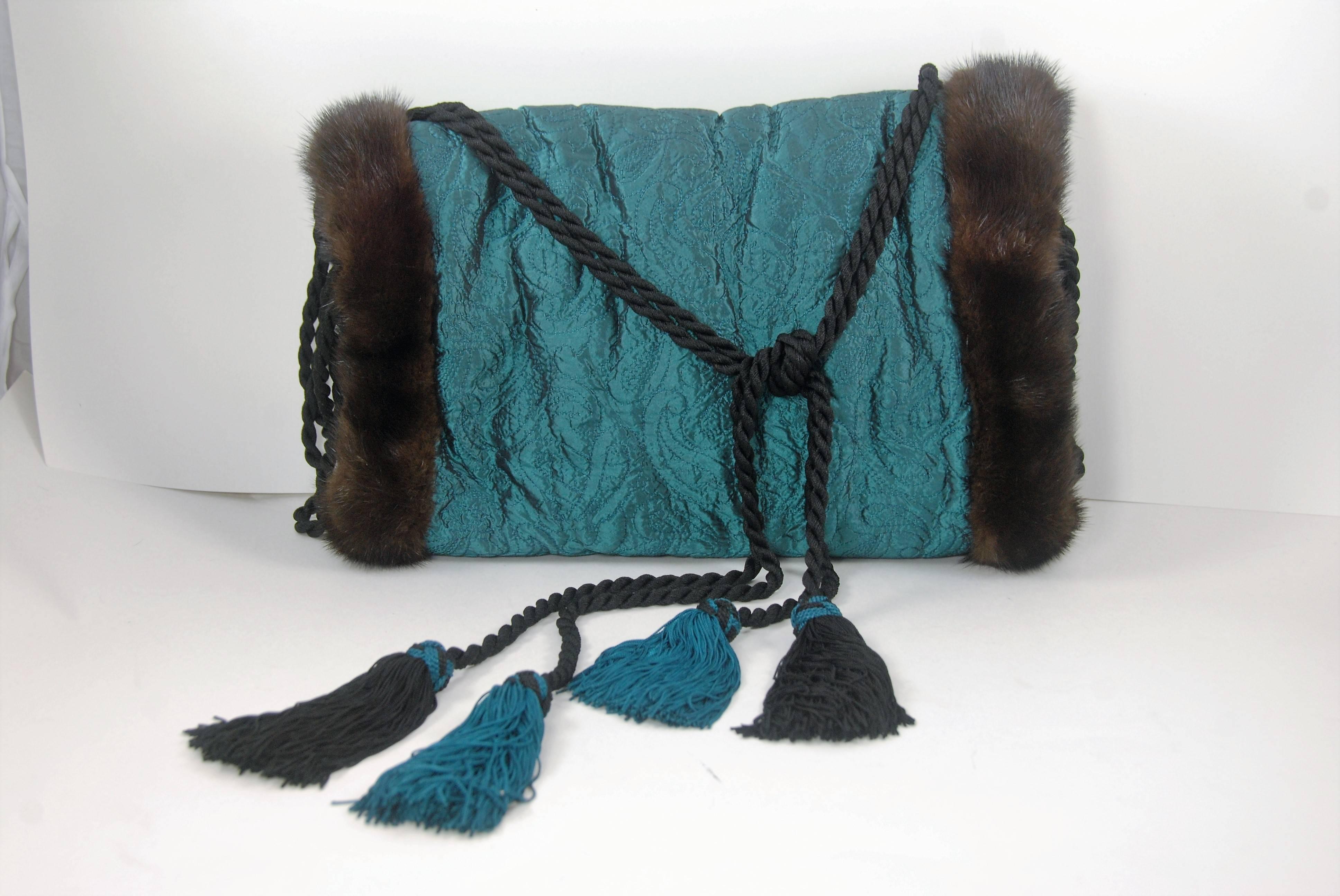 Isabel Canovas mink trimmed muff which is also fur lined. The lining is either sheared mink or another fur, I am not sure which it is. The outside of the muff is silk satin quilted fabric in blue with black undertones. The quilting is done is a