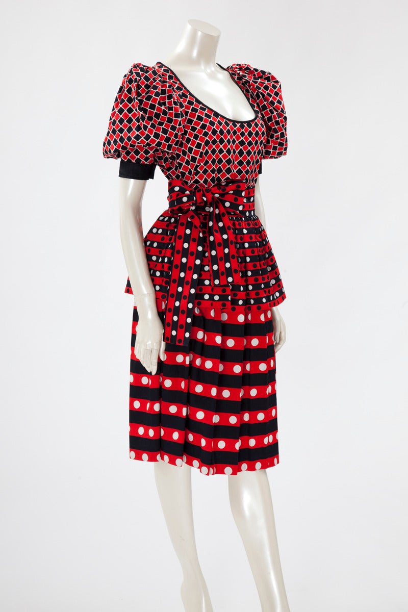 Emblematic YSL runway (see picture 11) Harlequin print top, skirt and matching belt from SS1983 collection. Contrasted with the skirt in the same red, jet black and white colours, the top has a scoop neckline and a black cotton yoke, closing with a