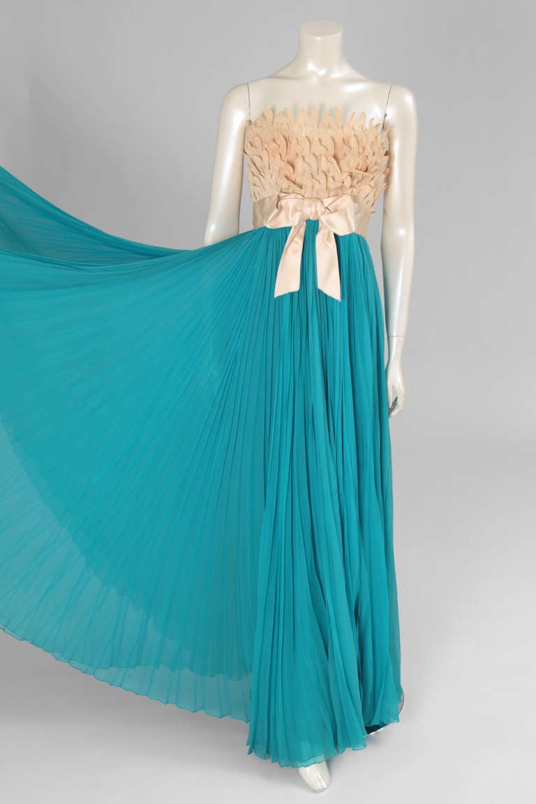 Extraordinary evening gown, empire-line, with ecru lace feathers covering the bodice with a satin sash above a deep turquoise skirt made of fine pleated silk chiffon.

Fits approx. : US 0-4 (small US 4) / FR 34-36 (small FR 36)

Measurements