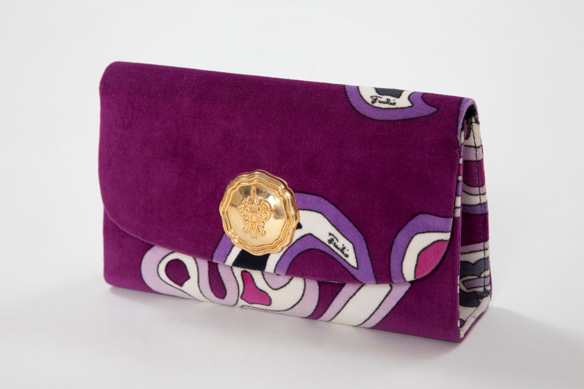 Wonderful pristine 60's Pucci printed velvet clutch with gold medallion hardware featuring Pucci's logo. Black silk interior. Snap closure.

Dimensions (approx.) :
L 20.5 x W 5.6 (bottom width) x H 12.8 cm / L 8.1 x W 2.2 (bottom width) x H 5