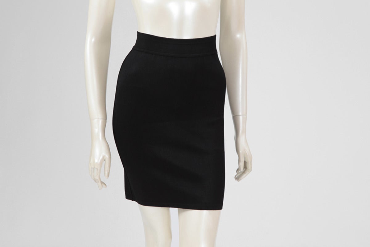 Sexy body-con Alaia black skirt dating from the 90's. Top-stitching. Unlined, the skirt is a size small but the stretchy fabric will accommodate a size medium as well. 

Fits approx. : US 2-6 / FR 36-38 

Measurements (taken flat) :
Waist