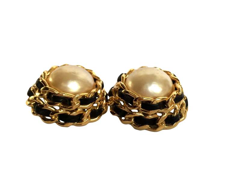 Vintage oversized Chanel clip-on earrings featuring a pearl with the trademark Chanel chain and leather.

Measurements :
Diameter 3.6 cm (1.4 in.) 
High 2 cm (0.8 in.)