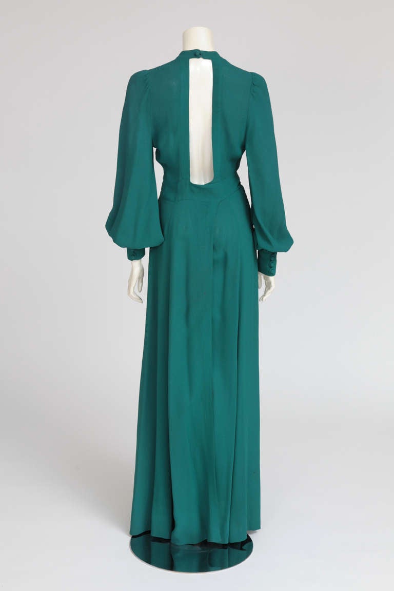 This wrap dress in emerald green moss crepe, is a flattering and glamorous low-cut plunge maxi-length silhouette. Typical of the 70’s Ossie Clark design, with his 30's inspiration signature. This sexy-romantic flowing gown closes also with 3 hooks