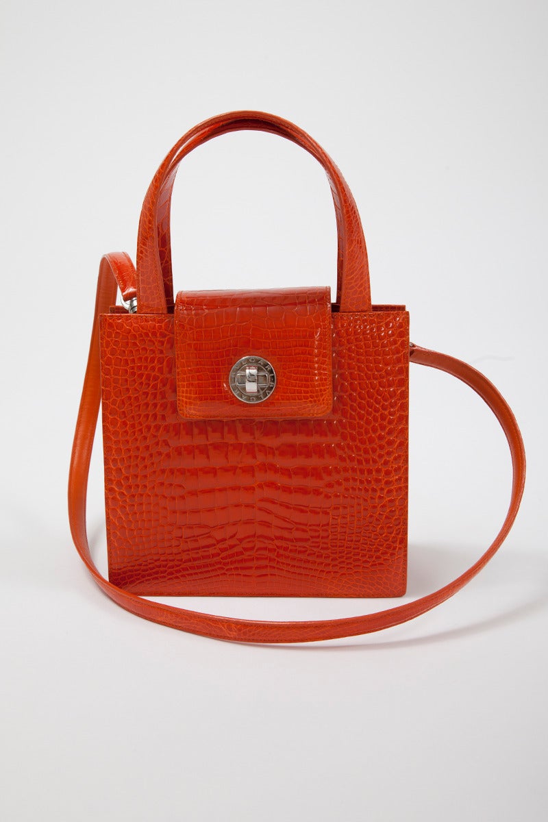 Sensational unused Bulgari vivid tangerine alligator handbag with silver palladium hardware. Detachable strap. The bag closes with a clasp (turn key lock) and one of the internal compartments has a ring-pull zipper. Both are stamped with the Bulgari