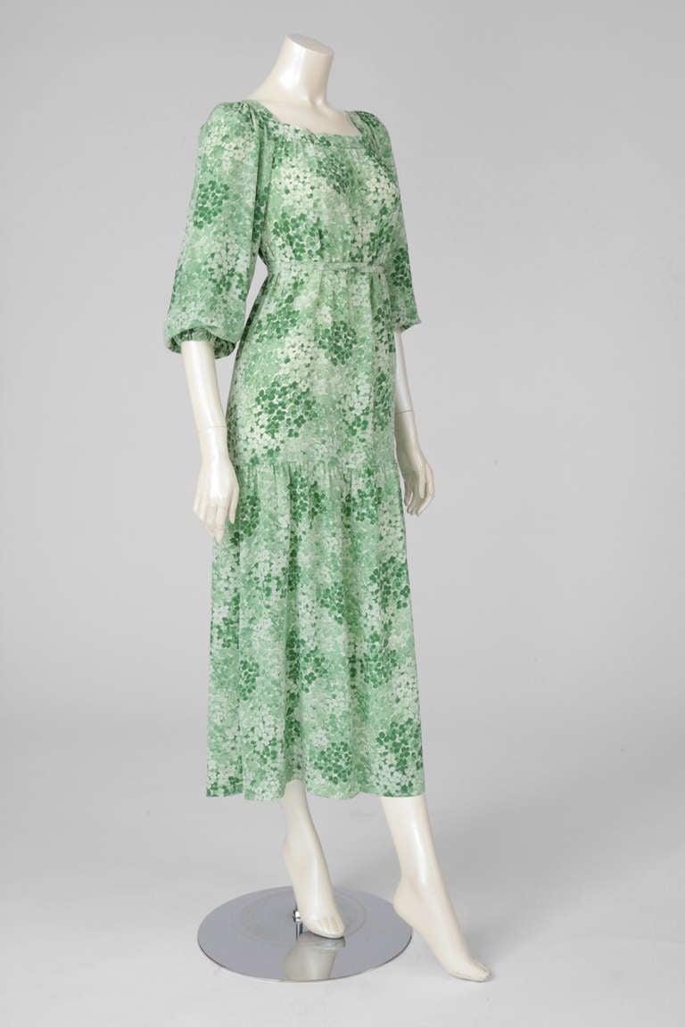 70's floral printed peasant style dress with square neckline and puffy long sleeves. Deep flounce at the lower thigh going down to the hem of the dress. Delicate Empire style stitched belt. Iconic actress Romy Schneider was wearing the same one, but