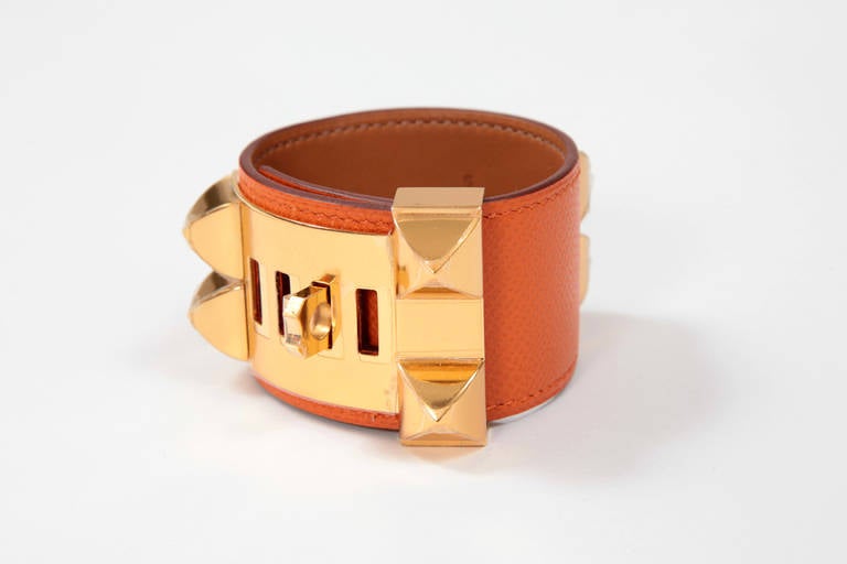 Hermes orange Collier de Chien Medor cuff bracelet in epsom leather and gold plated hardware. Pristine and unused condition with protective plastics still on the hardware. Size S with four slots to accommodate different wrist sizes. Stamped HERMES