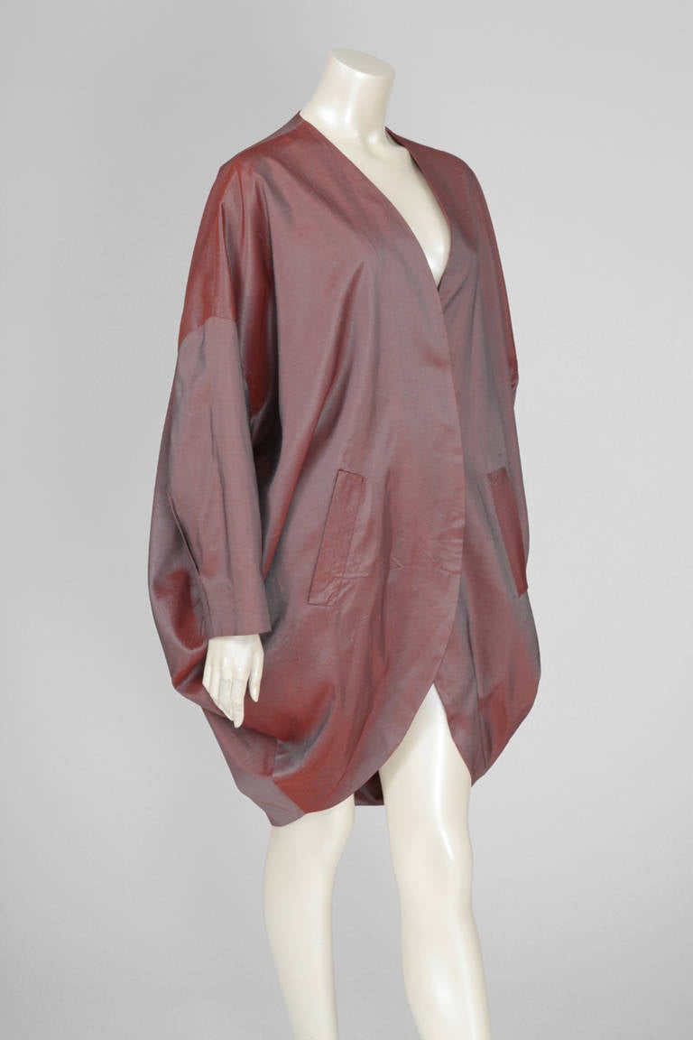 Cut out draped cocoon coat with colour changing effect, in light burgundy silk with hints of “verdigris” green. Raglan sleeves, two front pockets. Please see close-up pictures for details. Though IT 44 (US 8), it fits almost every size. Fully