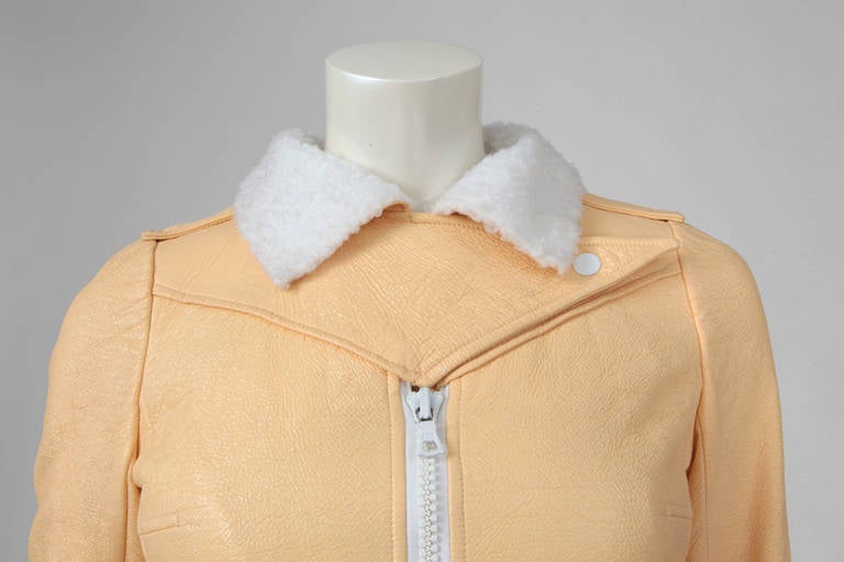 This eggshell-beige vinyl cropped bomber jacket is a rare example of the Hyperbole sportswear collection launched in 1971 by André Courrèges. Beautiful detailing throughout (shoulders and back). The coloured vinyl is contrasting with the white