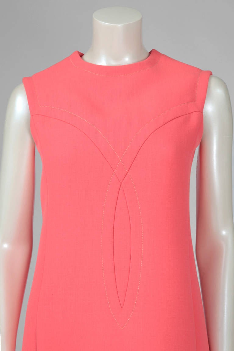 Inject some bright color into Winter with this early (c. 1965) Jean-Louis Scherrer neon coral pink dress. Recognizable 60's cut - A-line silhouette with stitching details. Inside pockets on the hips. The dress is equally pretty with or without the