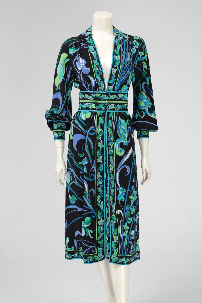 Beautiful Pucci silk dress from the early 70's. Kind of shirt collar with a V-plunge neckline. Dress closes with a zip and buttons in the lower part, six optional hooks for more or less coverage. Full sleeves that cuff at the wrist and cover