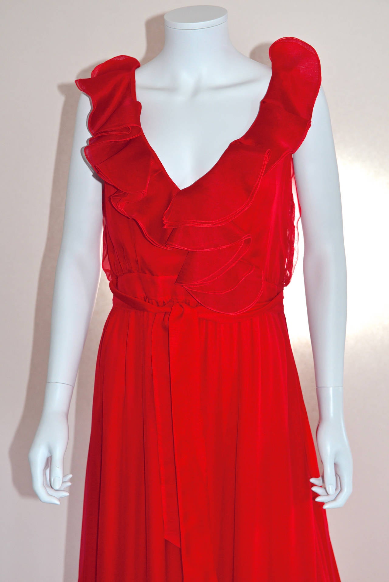 Wonderful Valentino red gown from the 2011-2012 Fall-Winter collection. Made of the most refined and soft silk chiffon, this gown features a frilled V neckline. Closes with a zip and press studs on the left side. The waist can be belted with two