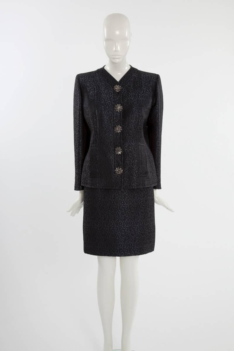 Late 80's -early 90's classical Yves Saint Laurent haute couture skirt suit. Constructed from midnight blue and gunmetal silk brocade, the jacket features a V-neckline and front pockets. Shoulders are padded creating a strong silhouette. Five large