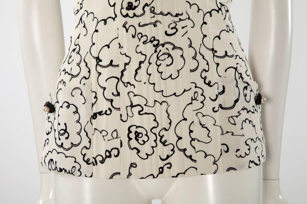 Iconic Chanel boned corset top from the Spring-Summer 1993 collection. Constructed to give a fitted silhouette, the corset top has a scoop neckline and two patch pockets with pearl detail buttons. Fully lined in white silk mini Chanel logo silk,