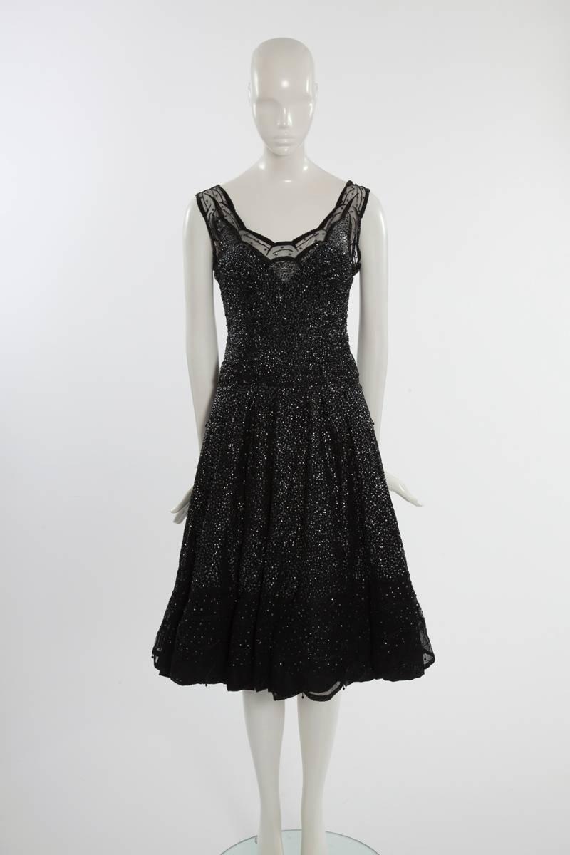 From the famous Milanese Pirovano fashion house which was then favoured by the Jet-Set, this late 50's - early 60's cocktail dress is embellished with hundreds of shimmering sequins, micro pearls and jet black drops. Beautifully crafted from black