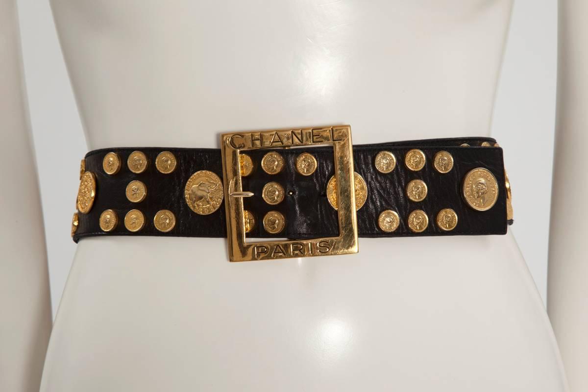 Very rare 90's Chanel piece, featuring coins of different sizes on a large black lambskin belt. Ten big coins picture various Chanel symbols (for example the ear of wheat, the double C or the Chanel n° 5 flask). The small coins feature Coco Chanel’s